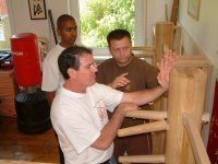 Grandmaster Andreas Hoffmann explains Mook Yan Jong techniques to Alan and Anand.